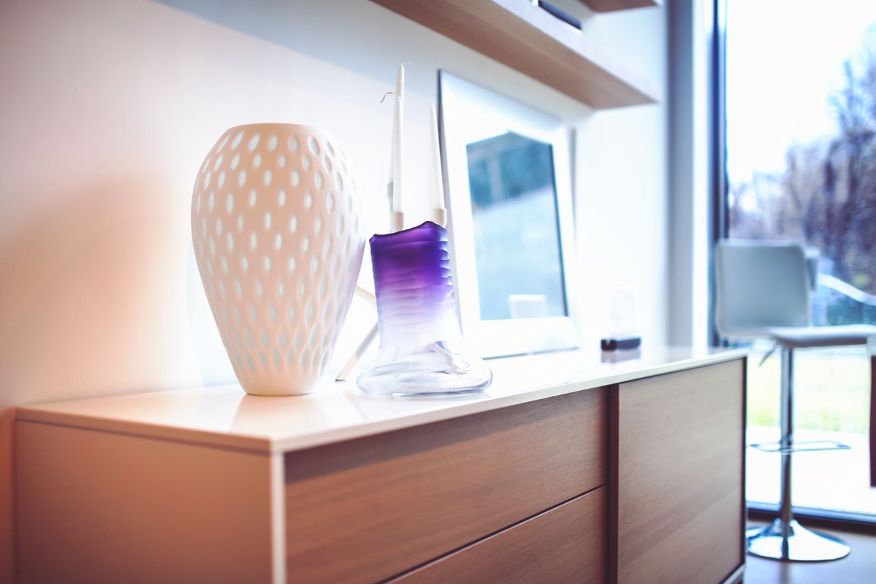 Home A stylish modern interior featuring decorative vases on a wooden sideboard, exuding contemporary design.